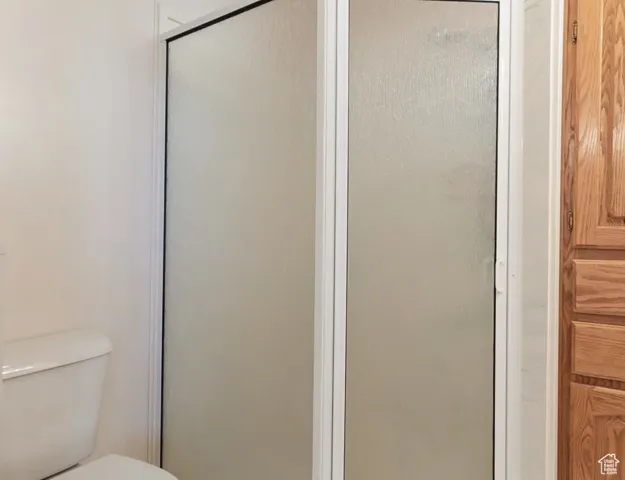 Bathroom featuring toilet and a stall shower