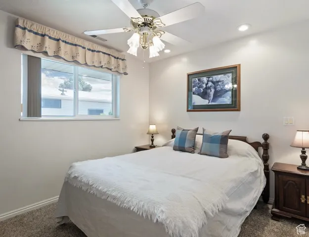 Carpeted bedroom featuring a ceiling fan and recessed lighting