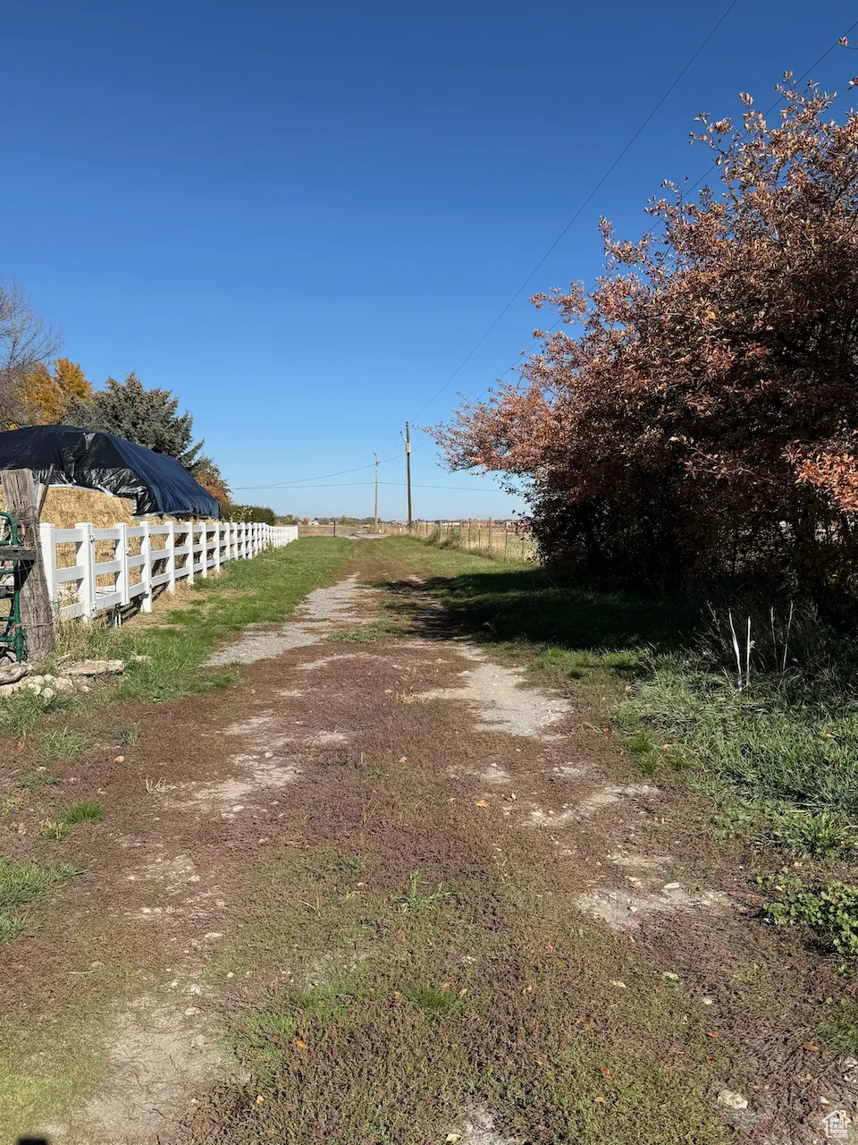 View of dirt / gravel road featuring a view of rural / pastoral area