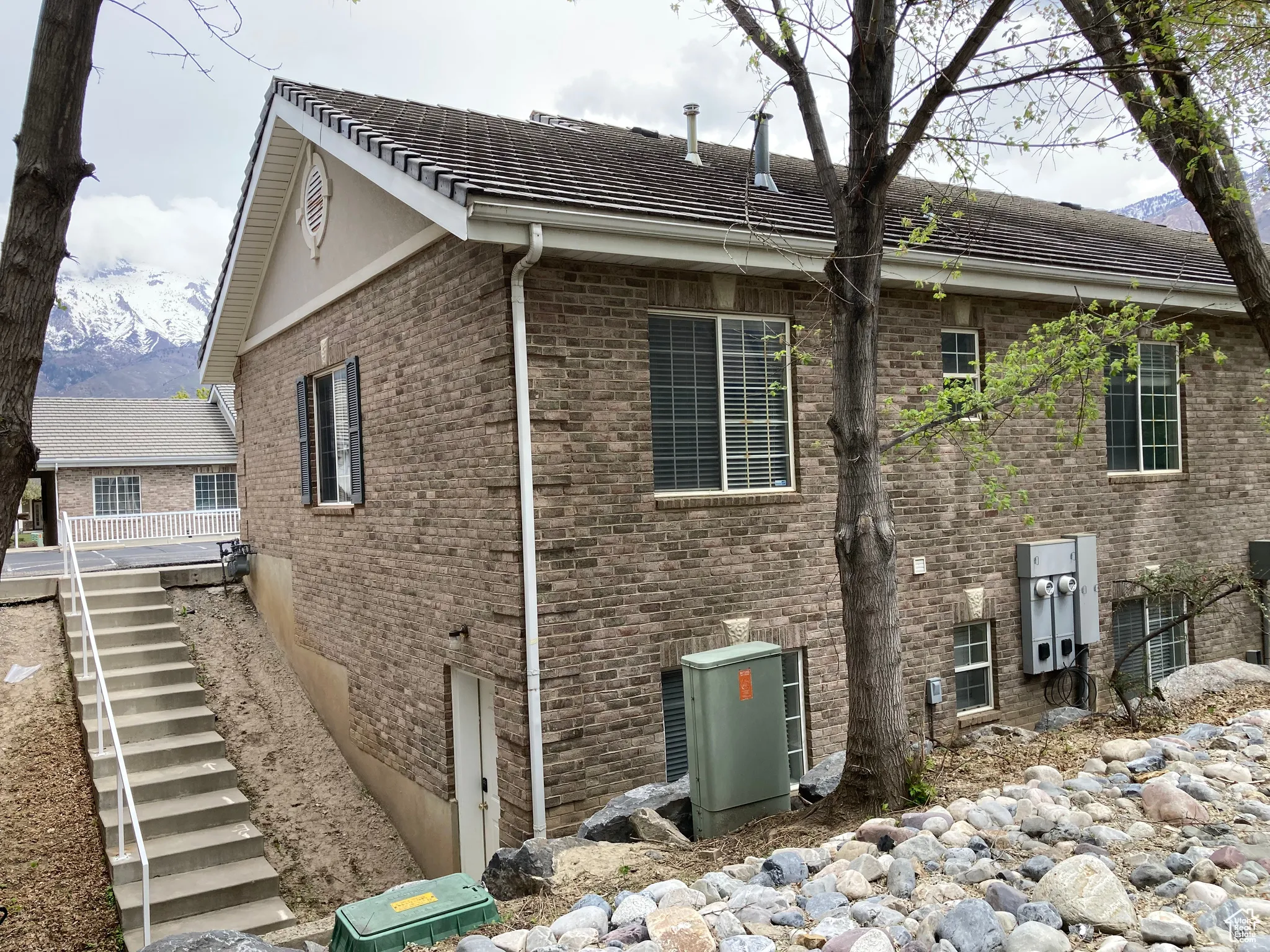 View of side of property featuring brick siding and stairs