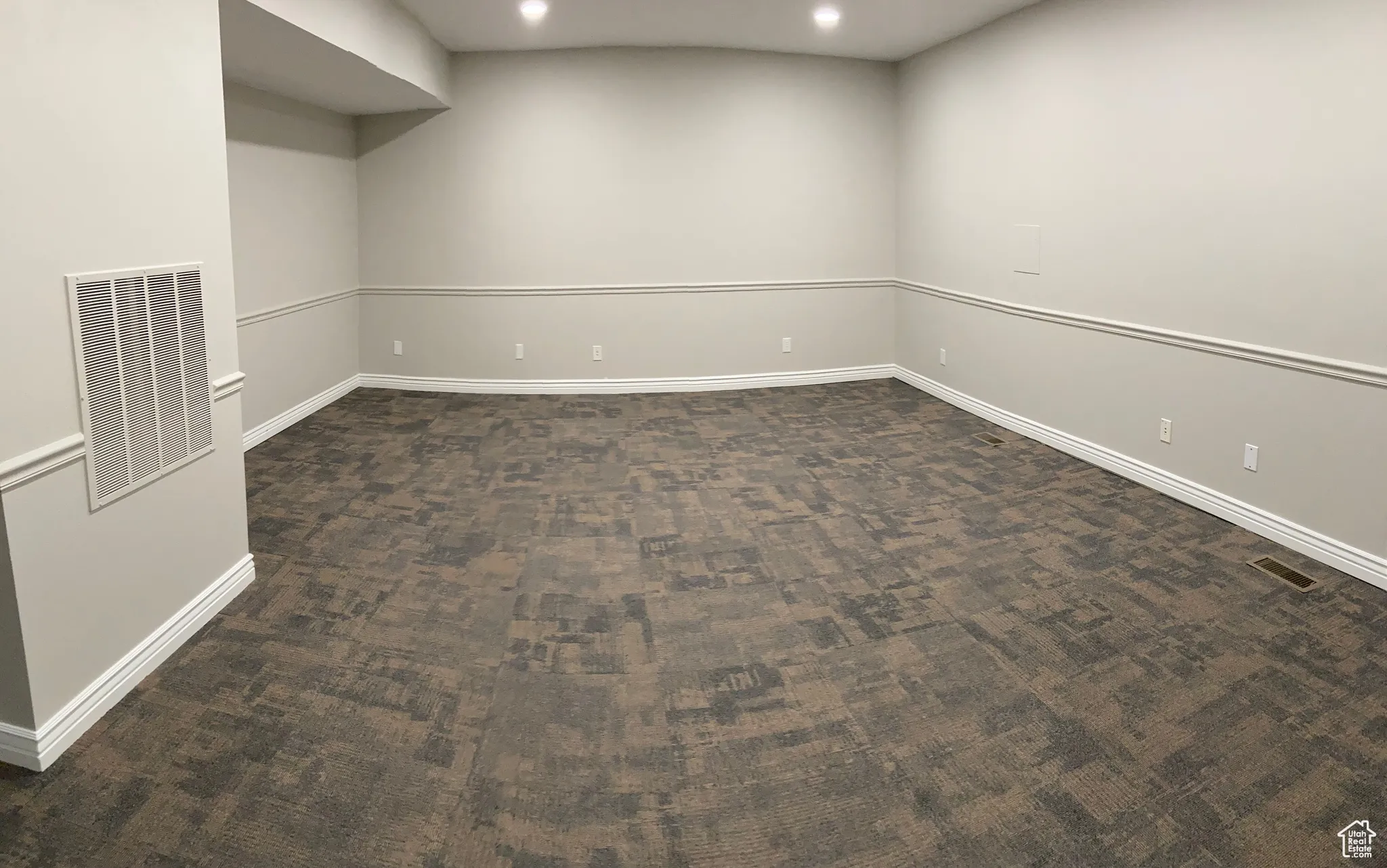 Empty room with dark carpet and recessed lighting