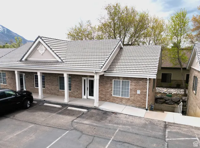 View of front of home with brick siding and uncovered parking