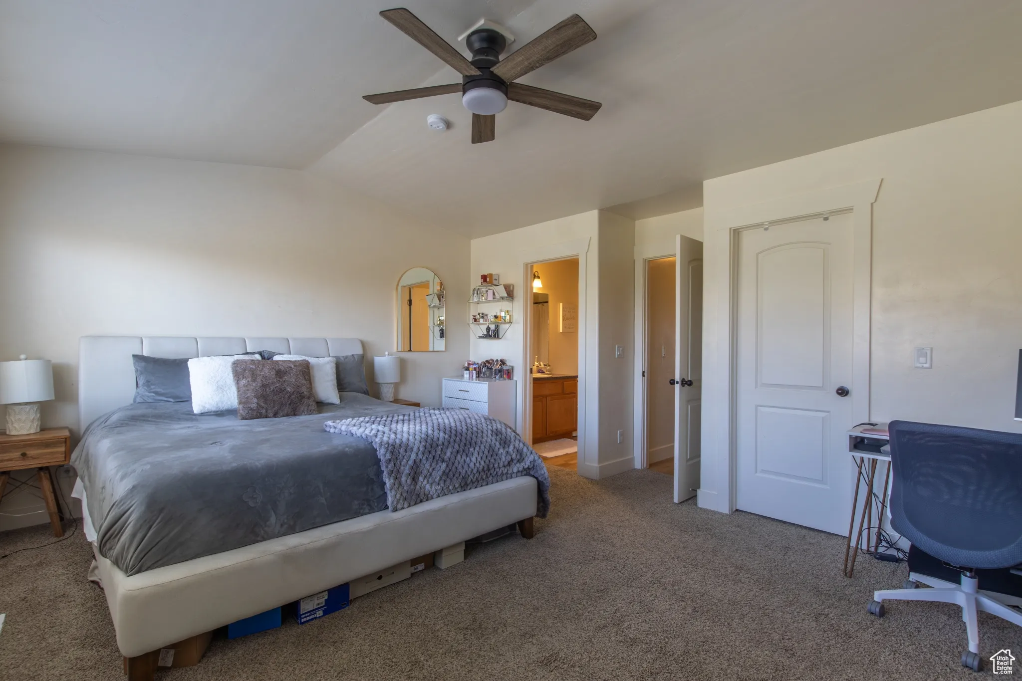 Bedroom featuring carpet flooring, vaulted ceiling, connected bathroom, and a ceiling fan