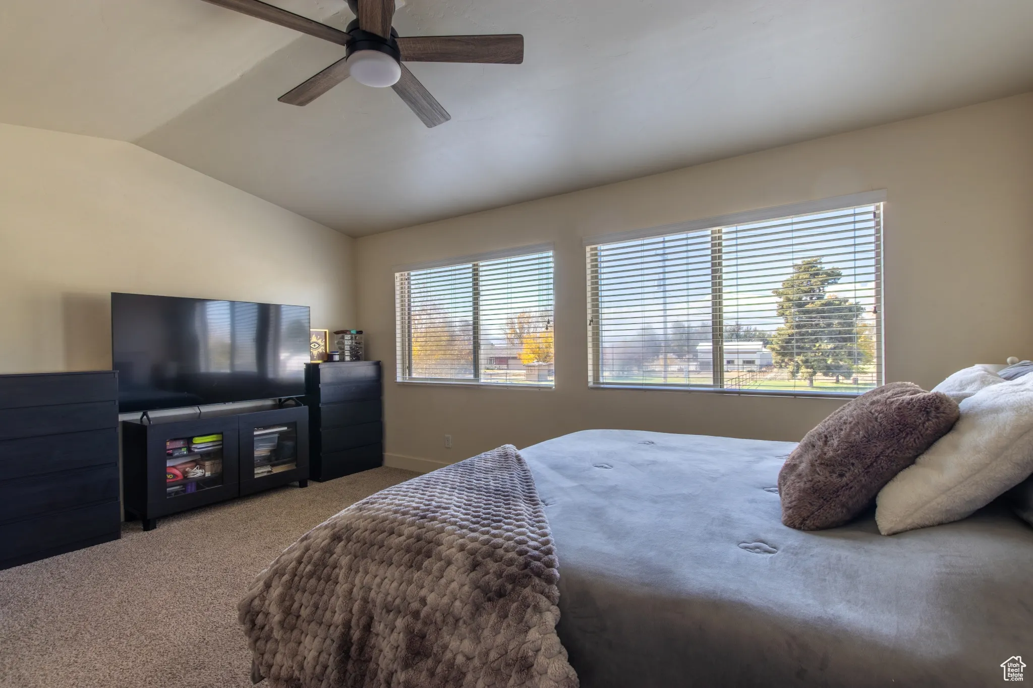 Bedroom with carpet flooring, vaulted ceiling, and ceiling fan