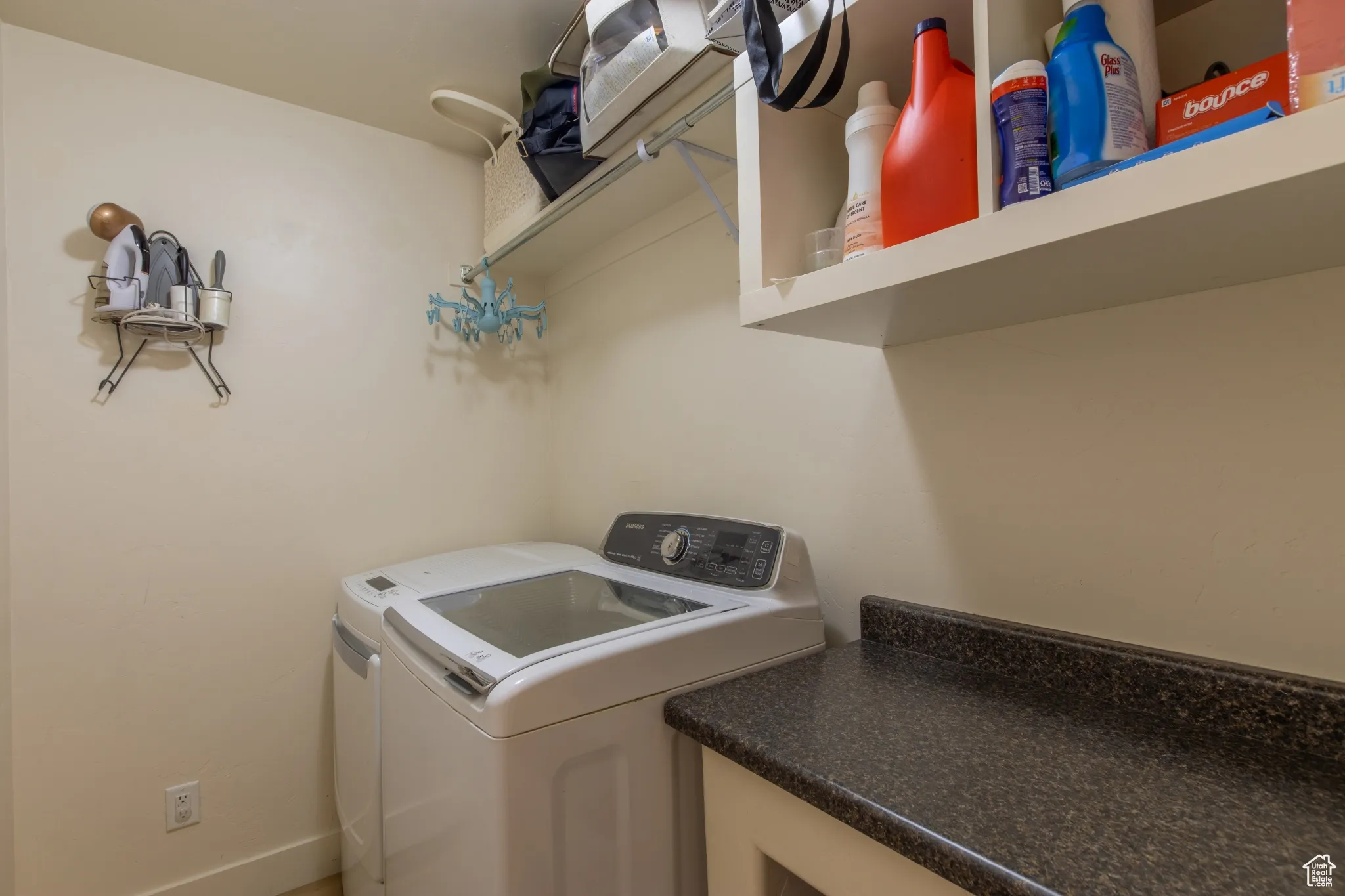 Laundry room featuring washing machine and clothes dryer and baseboards