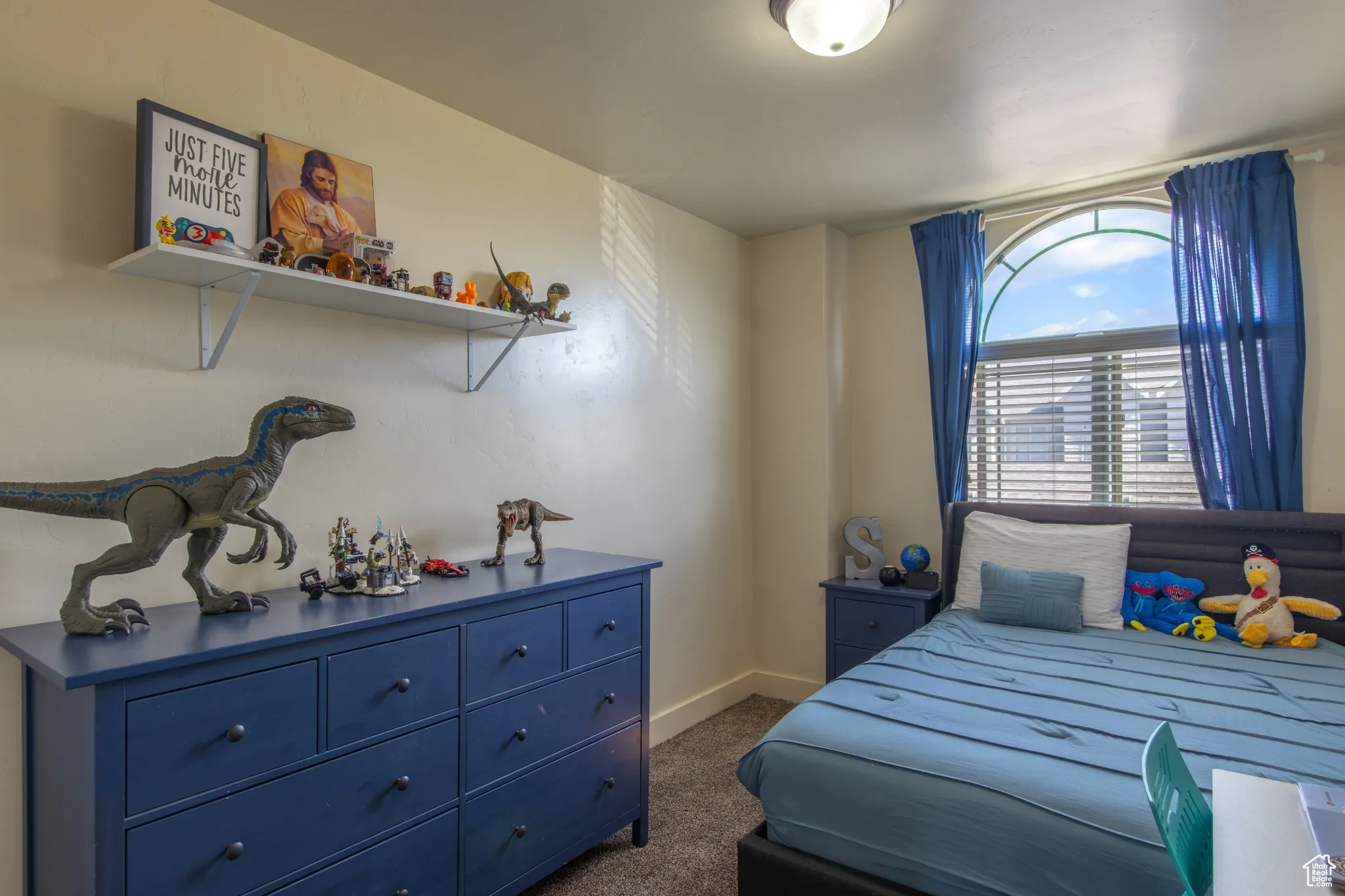 Bedroom featuring dark colored carpet and baseboards