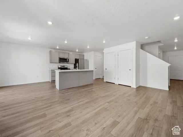 Unfurnished living room with light wood-style floors, recessed lighting, and a textured ceiling