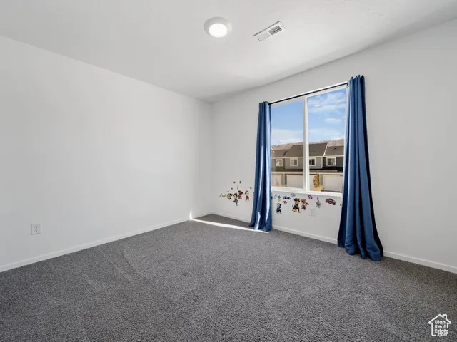 Carpeted spare room with baseboards