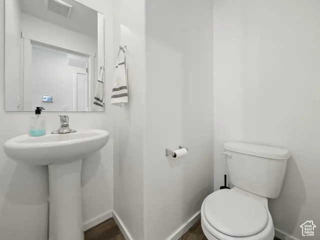Half bath featuring dark wood finished floors