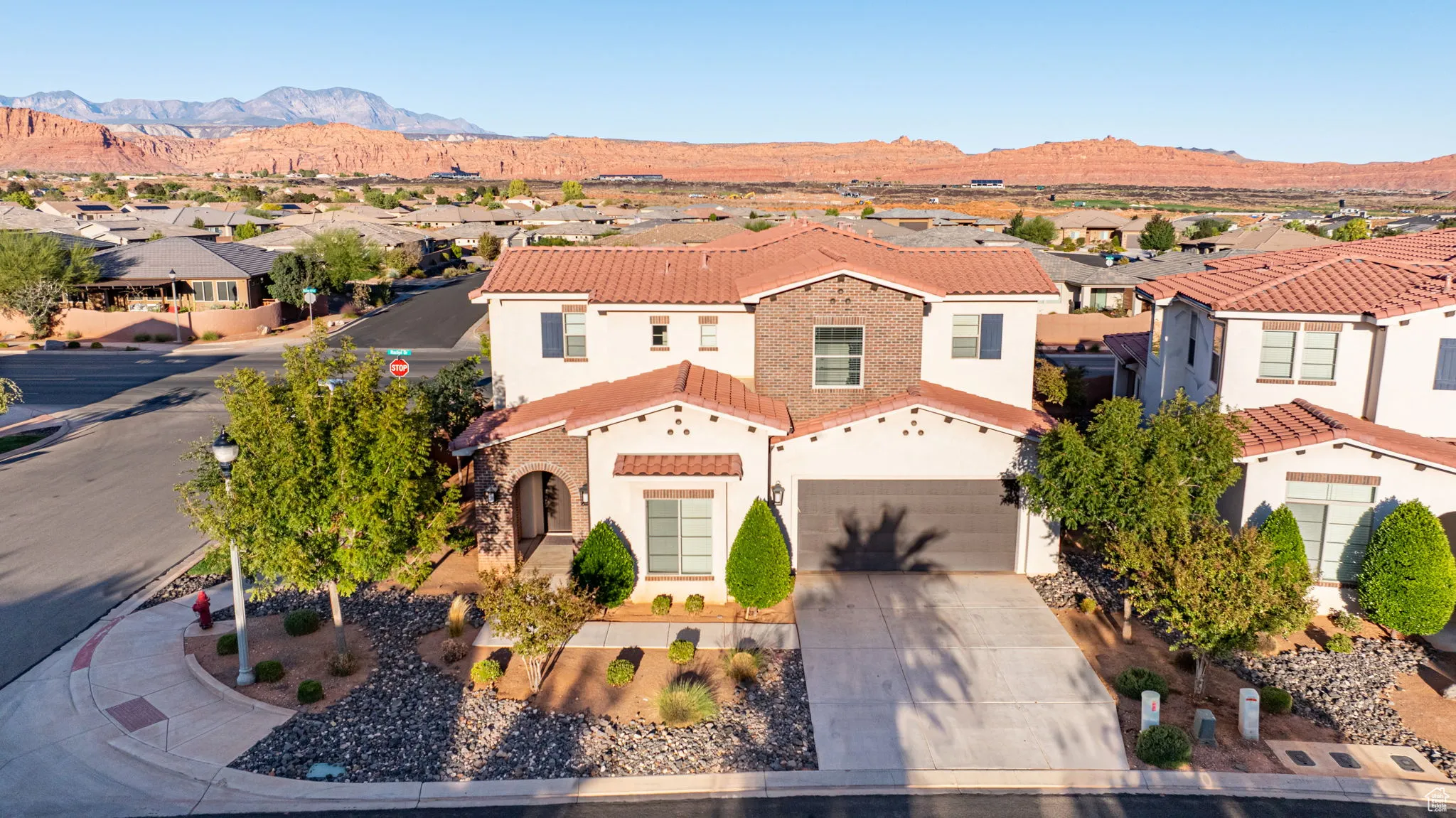 Mediterranean / spanish home with a residential view, a tile roof, driveway, and stucco siding