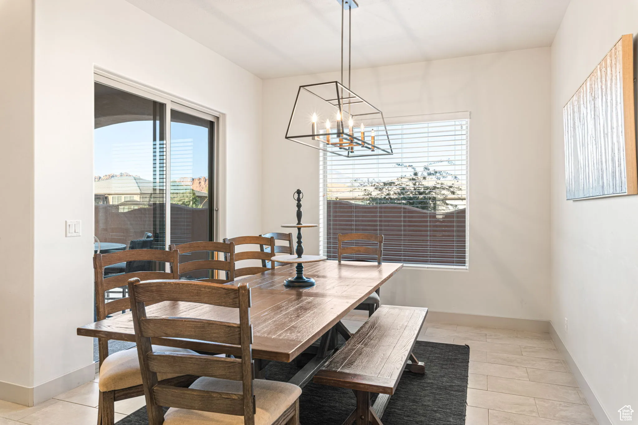 Dining room with light tile patterned floors and a chandelier