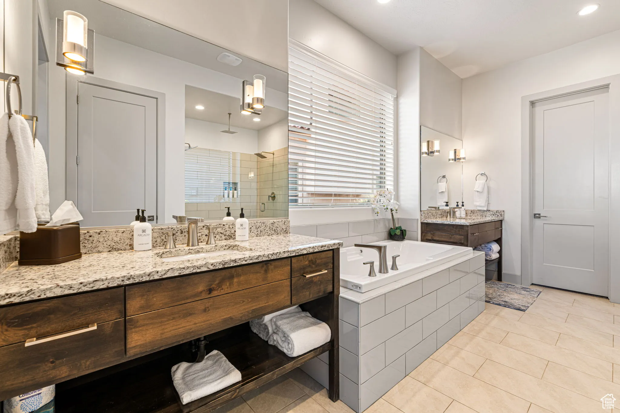 Bathroom with a shower stall, two vanities, a garden tub, light tile patterned floors, and recessed lighting
