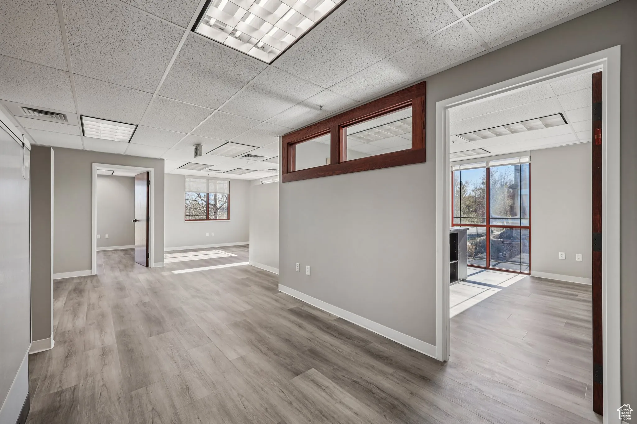 Empty room featuring a paneled ceiling and light wood-style flooring