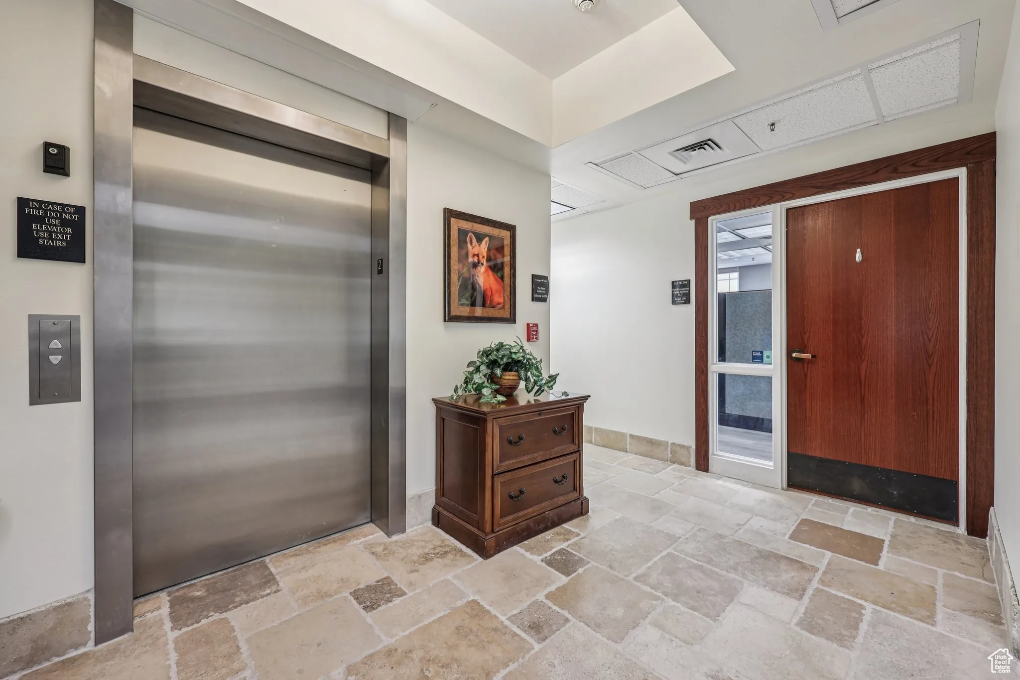 Entrance foyer featuring elevator and stone tile flooring