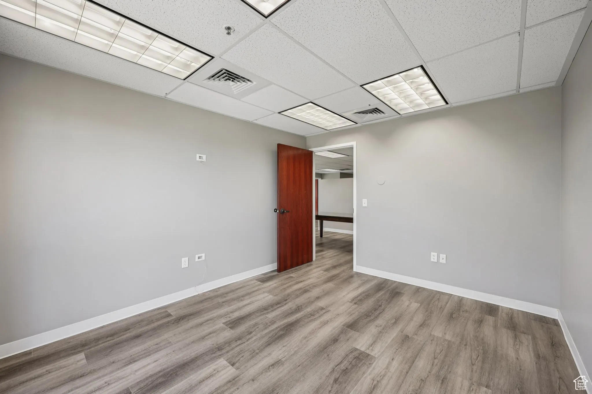 Unfurnished room featuring a paneled ceiling and wood finished floors