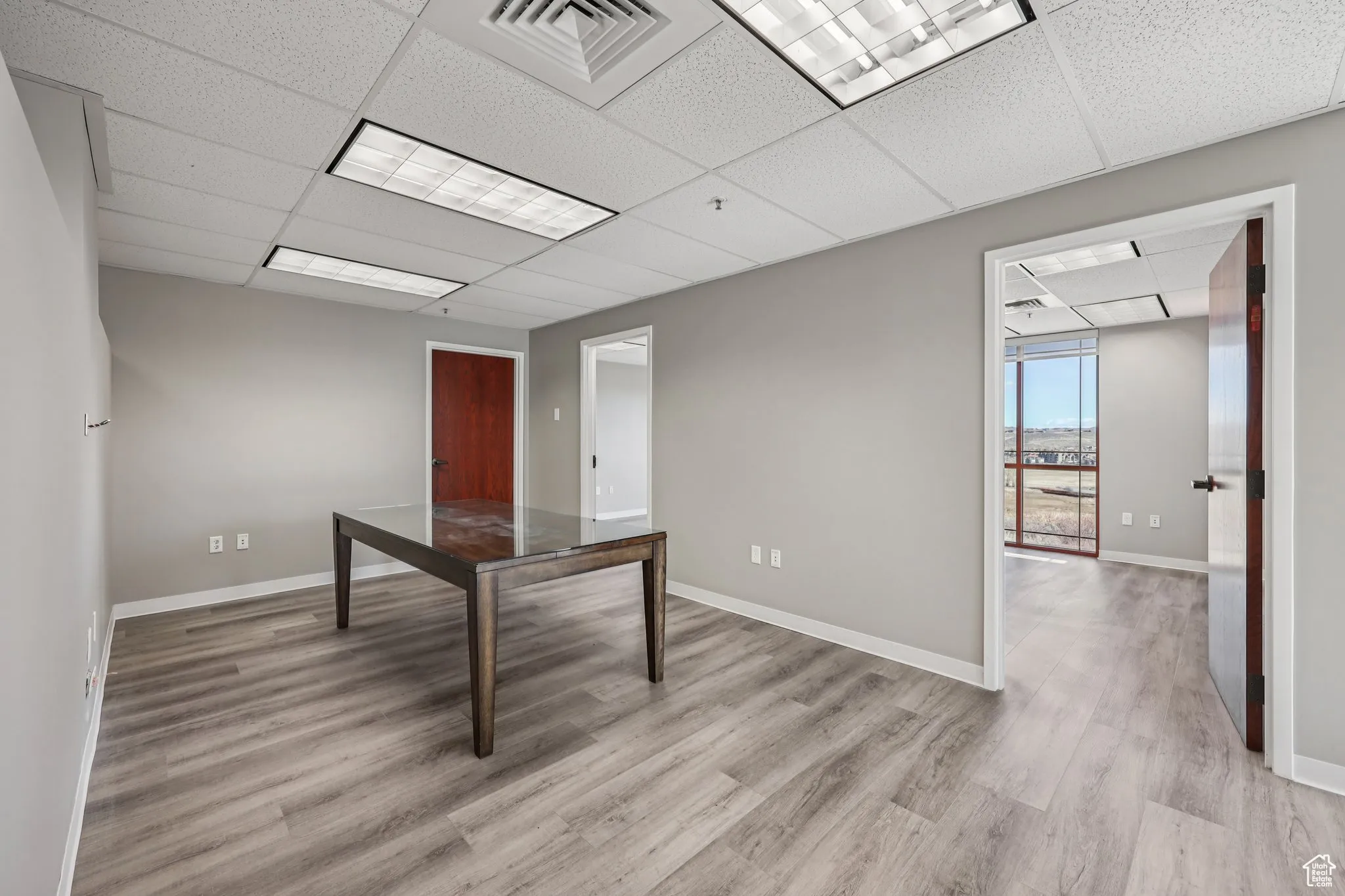 Unfurnished office featuring a drop ceiling and light wood-style floors