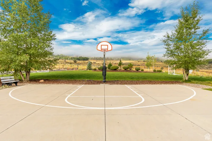 View of basketball court featuring community basketball court and a lawn