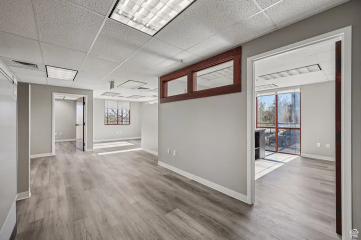 Empty room featuring a paneled ceiling and light wood-style flooring