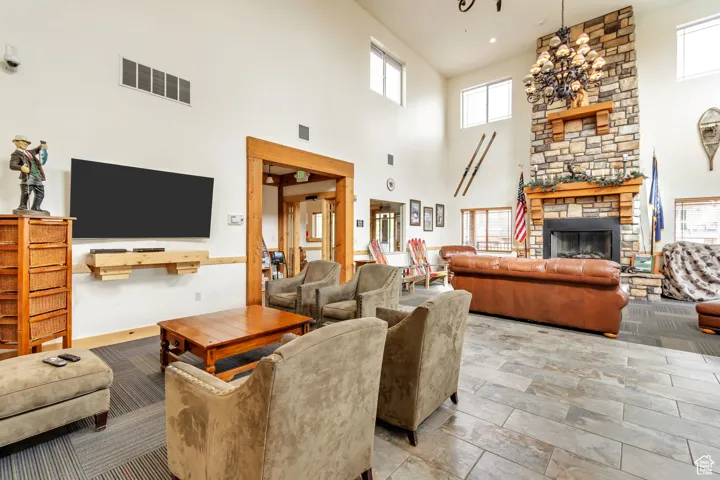 Living area with healthy amount of natural light, a fireplace, and a towering ceiling