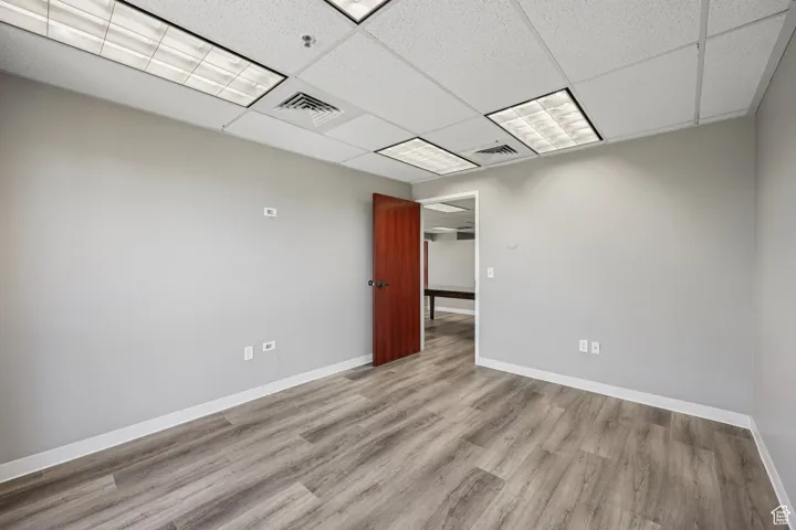 Unfurnished room featuring a paneled ceiling and wood finished floors