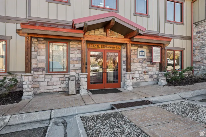Doorway to property with stone siding, french doors, and board and batten siding