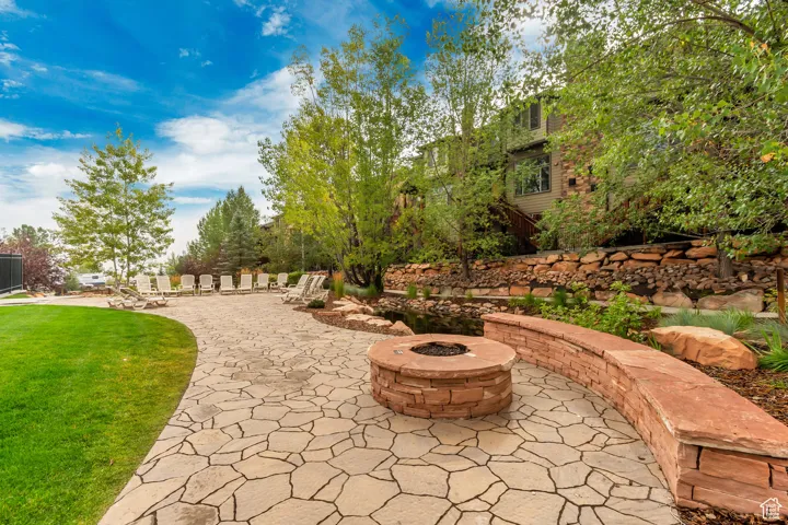 View of home's community featuring an outdoor fire pit, a patio area, and a yard