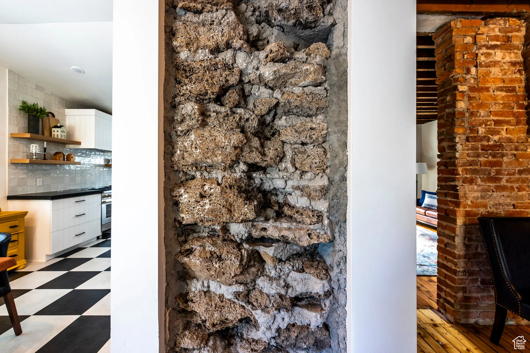 Detailed view of decorative backsplash, tile patterned floors, and stainless steel oven