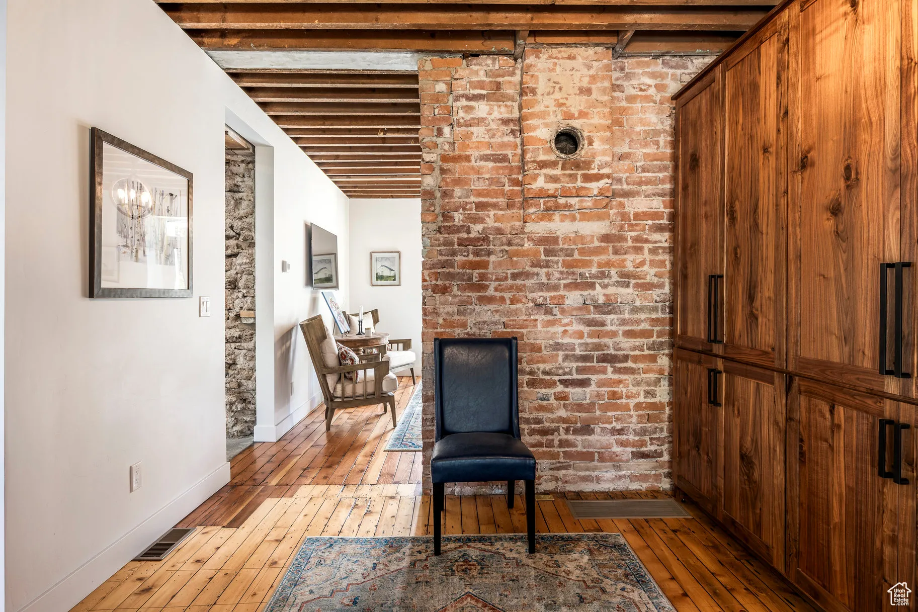Living area featuring wood-type flooring and beam ceiling