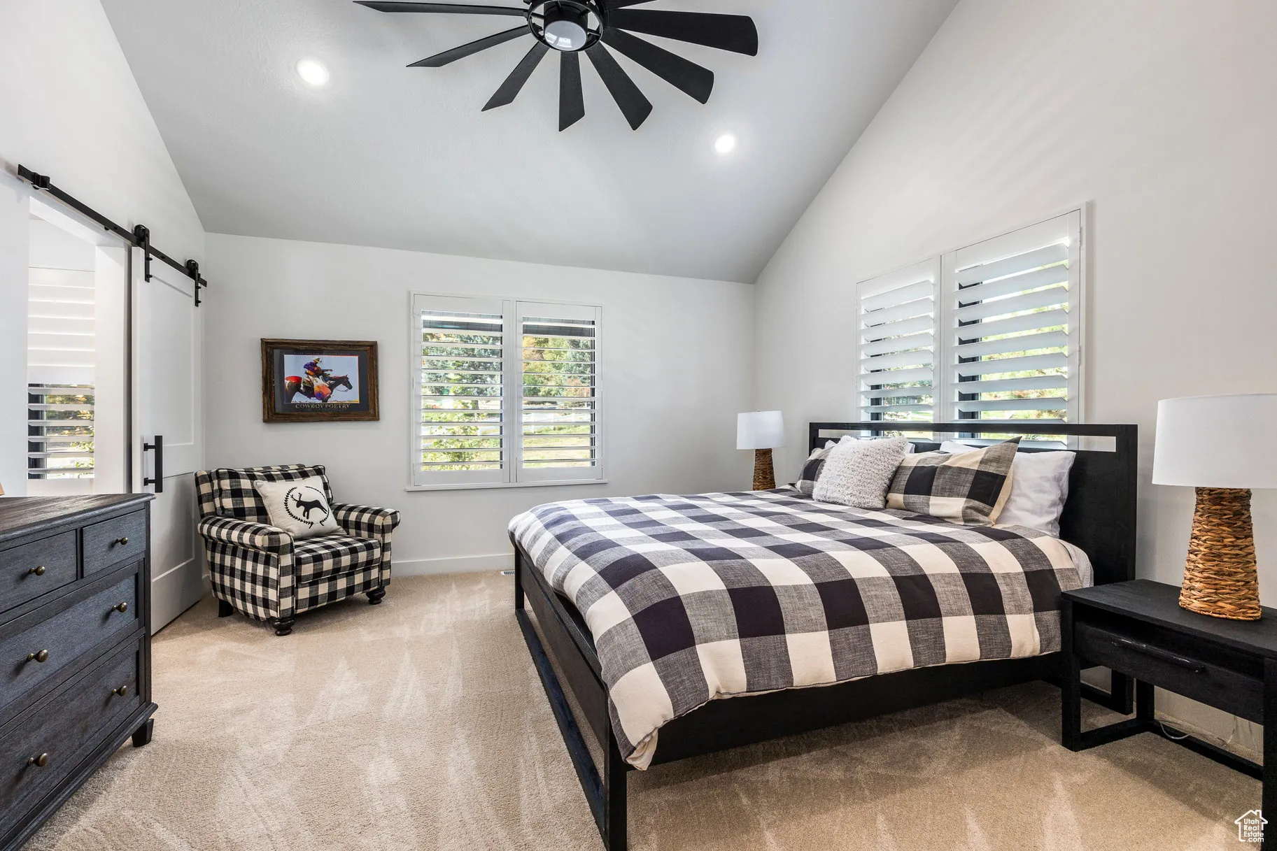Bedroom featuring light colored carpet, a barn door, multiple windows, high vaulted ceiling, and recessed lighting