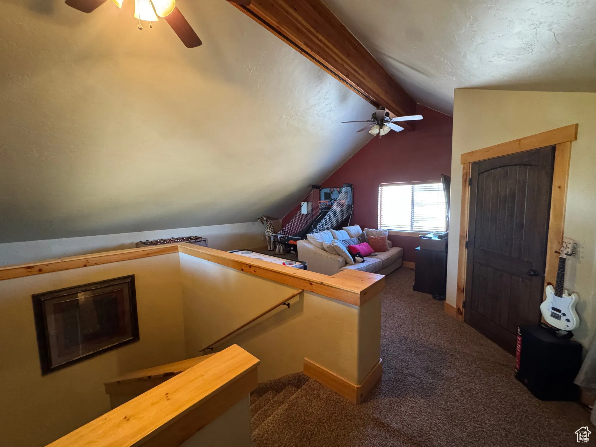 Bonus room featuring a ceiling fan, dark colored carpet, and a textured ceiling