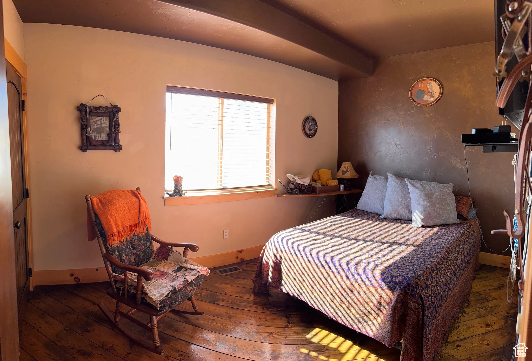 Bedroom featuring dark wood-style flooring and beam ceiling