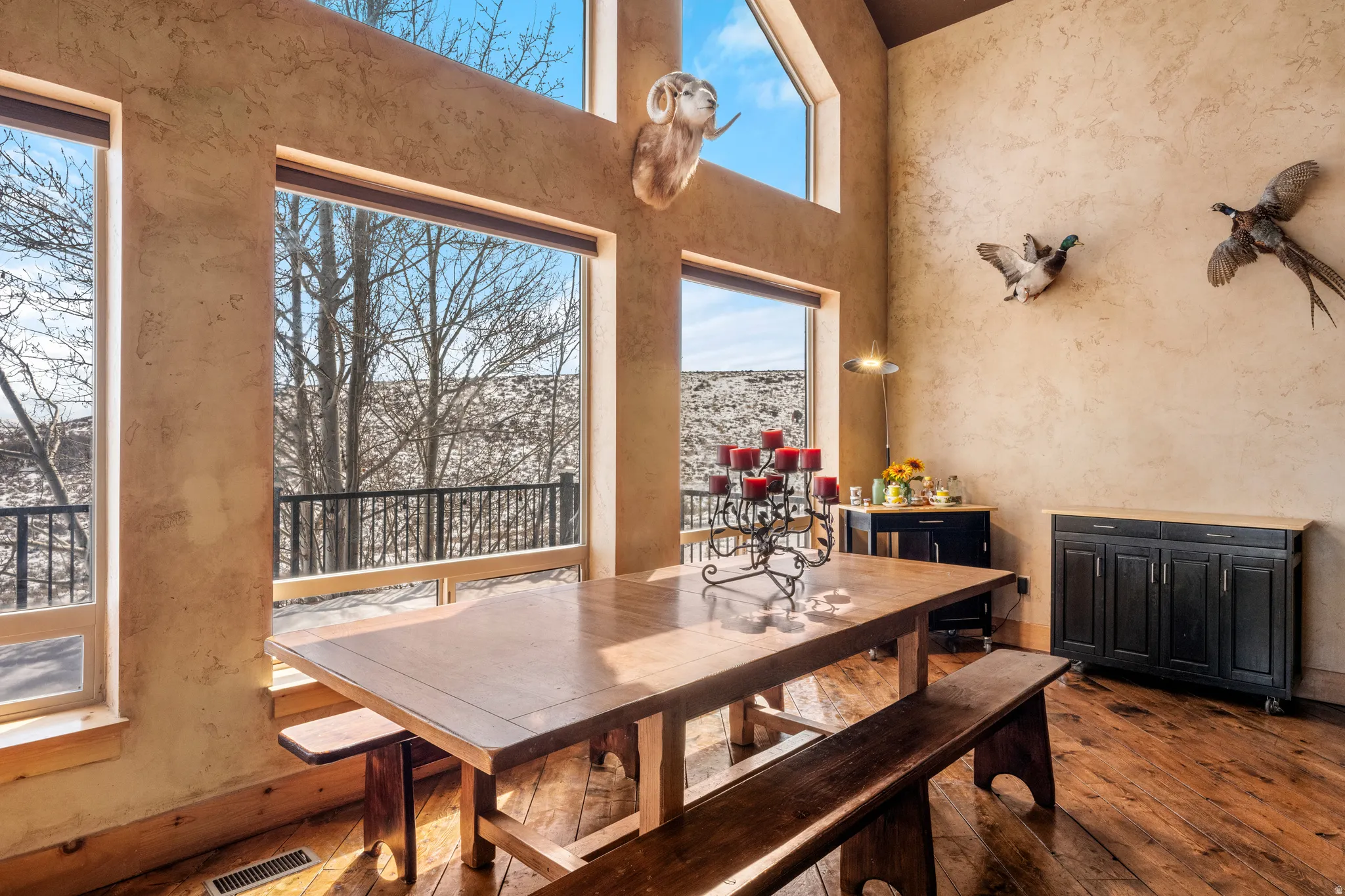 Dining room with a towering ceiling and dark wood finished floors