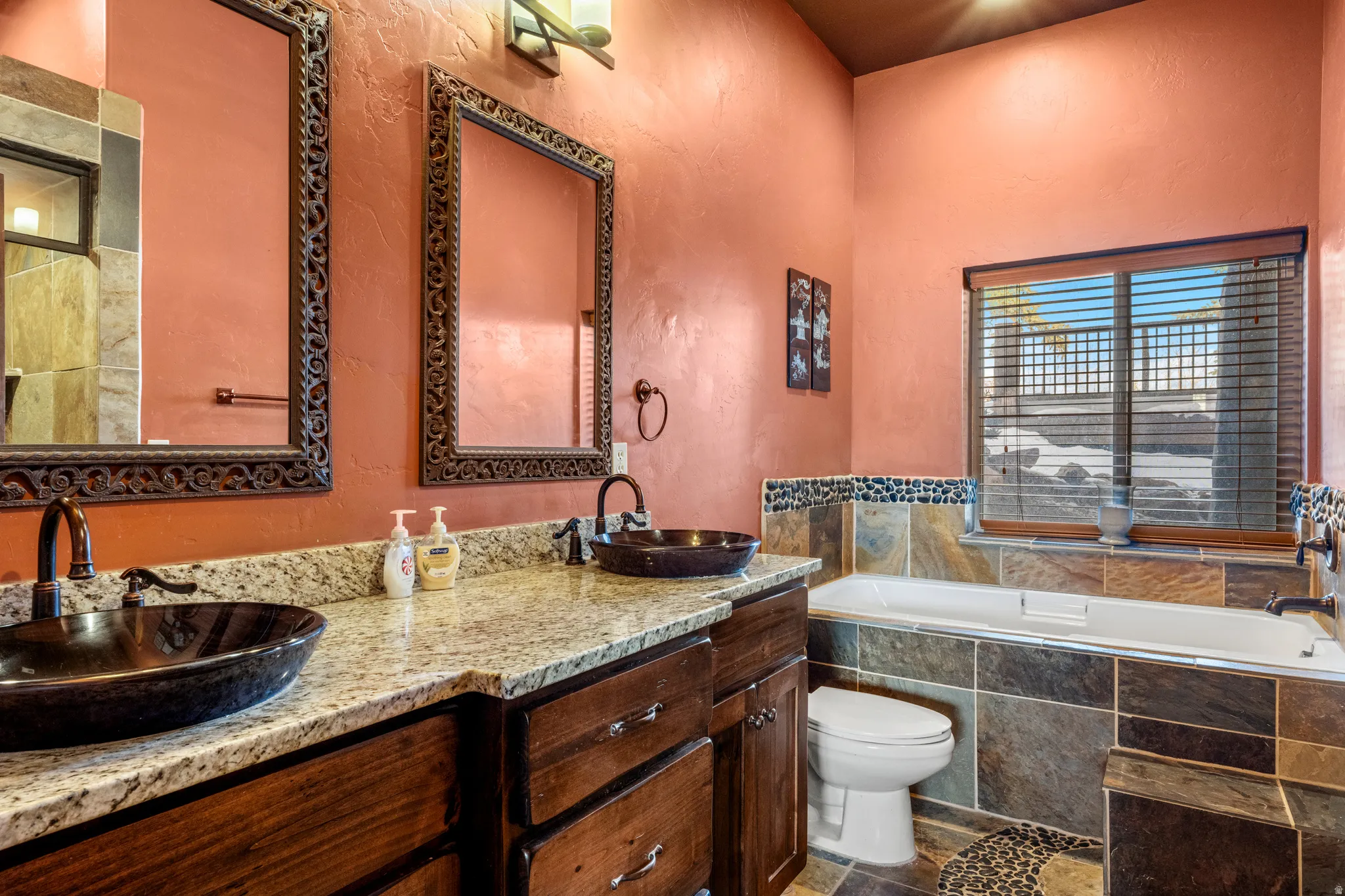 Full bath with a bath, a textured wall, and double vanity