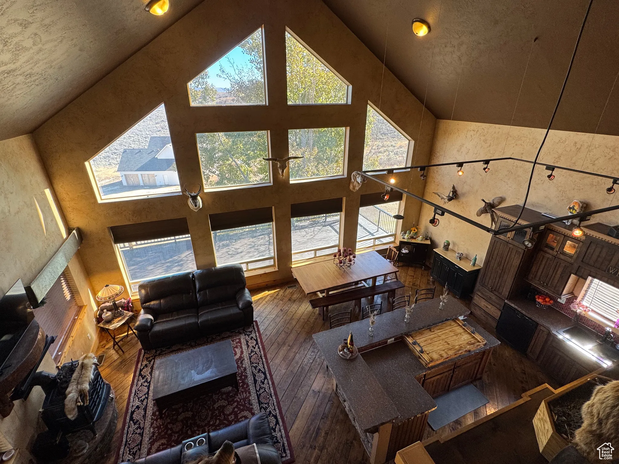 Living area with high vaulted ceiling and hardwood / wood-style floors