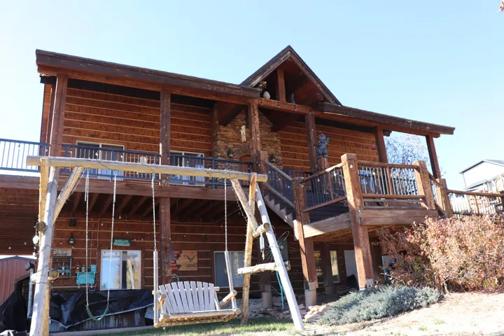 Rear view of property featuring a deck and a patio area