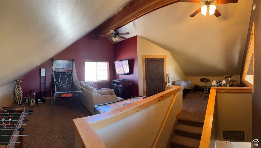Additional living space featuring carpet flooring and a ceiling fan