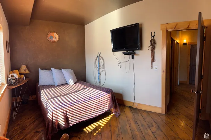 Bedroom with baseboards and hardwood / wood-style flooring