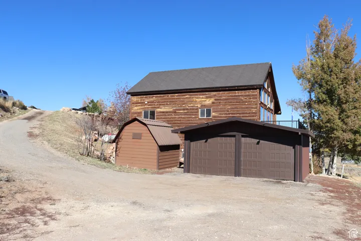 View of front of home featuring an outbuilding, driveway, and a garage