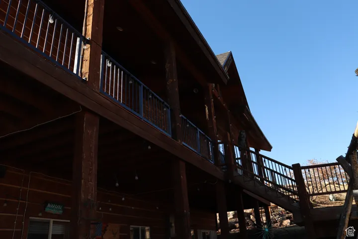 View of property exterior with a wooden deck and stairs