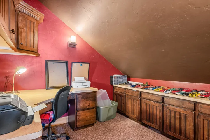 Office with vaulted ceiling, carpet flooring, a textured wall, and a textured ceiling