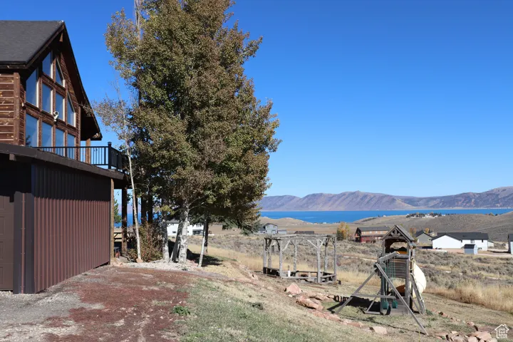 View of yard featuring a water and mountain view and a balcony
