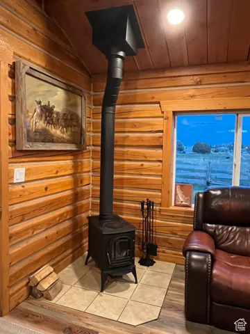 Living area with a wood stove, wooden ceiling, and wood finished floors