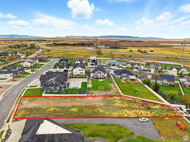Aerial view of residential area with mountains and property parcel outlined