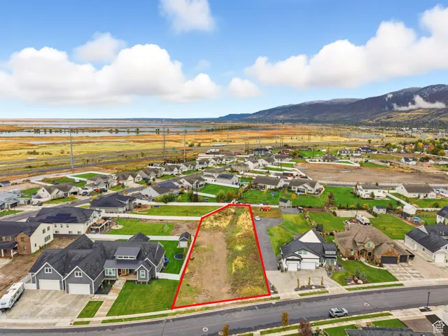 Aerial perspective of suburban area with property parcel outlined and mountains