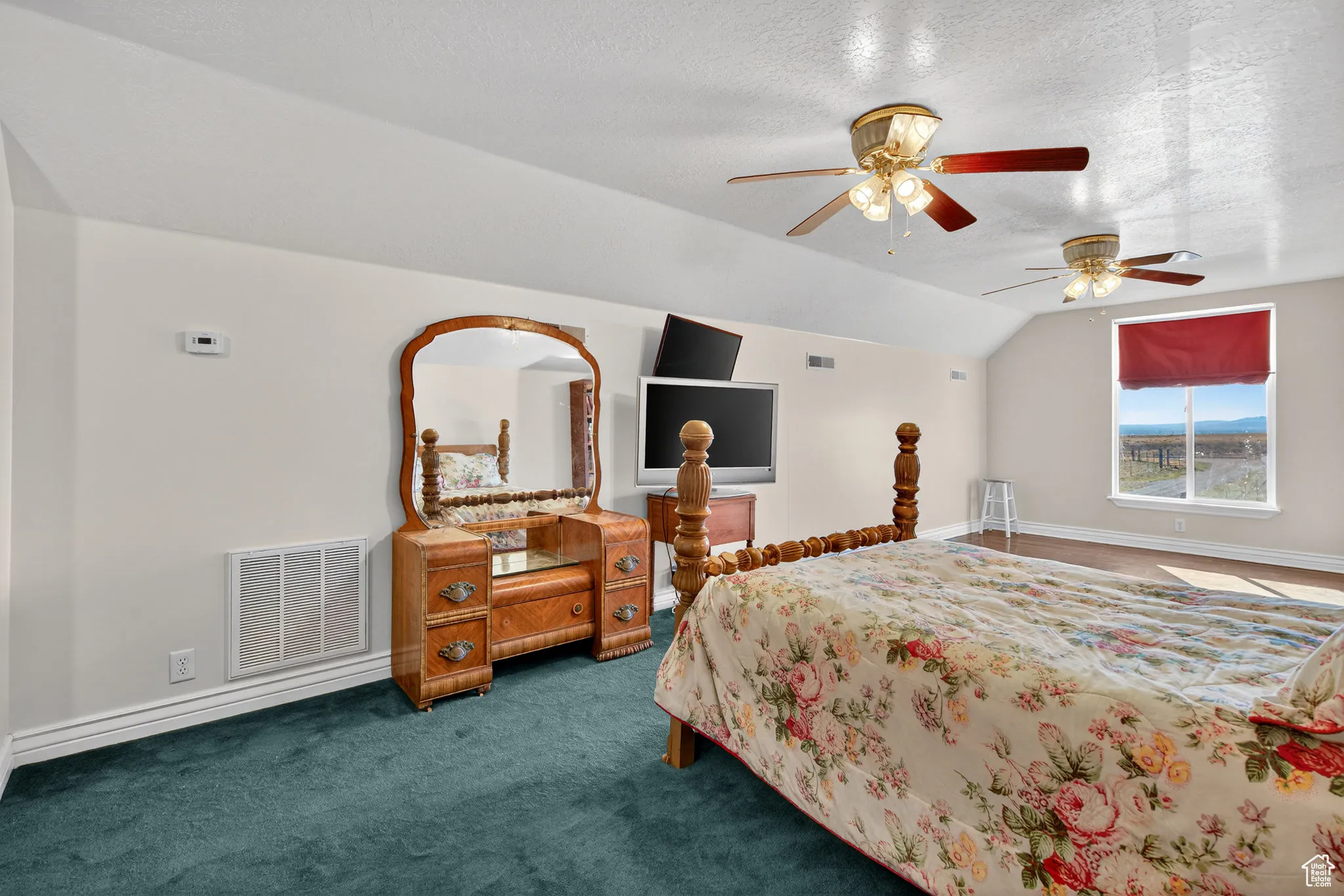Garage bedroom with a ceiling fan, and carpet flooring.