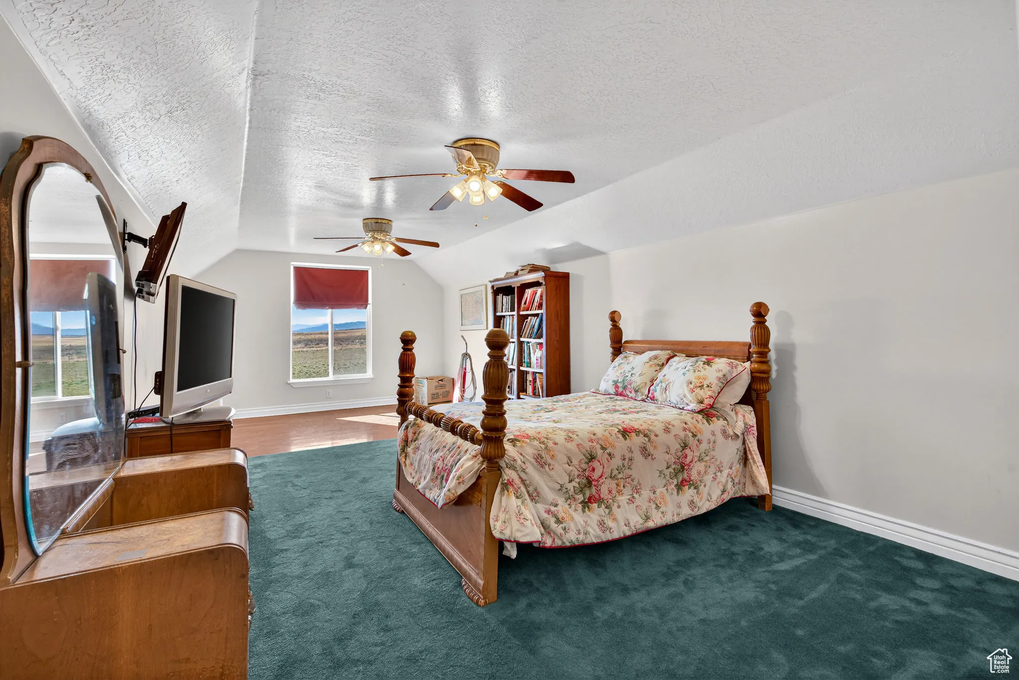 Garage bedroom featuring a lofted ceiling, and a ceiling fan.