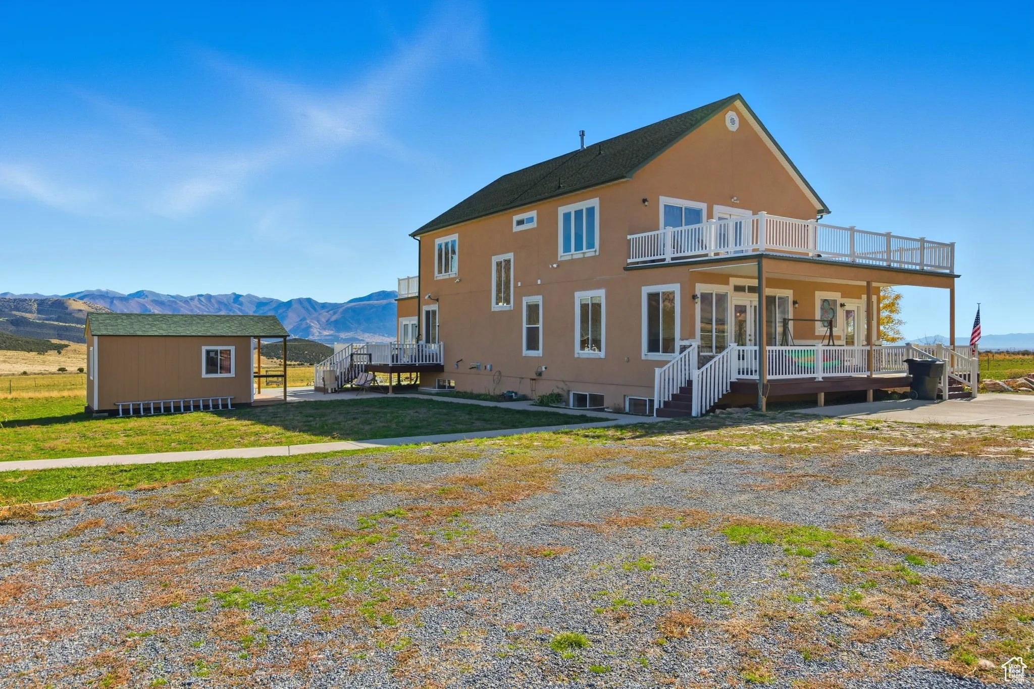North side of home featuring a mountain view, deck, and a out building.