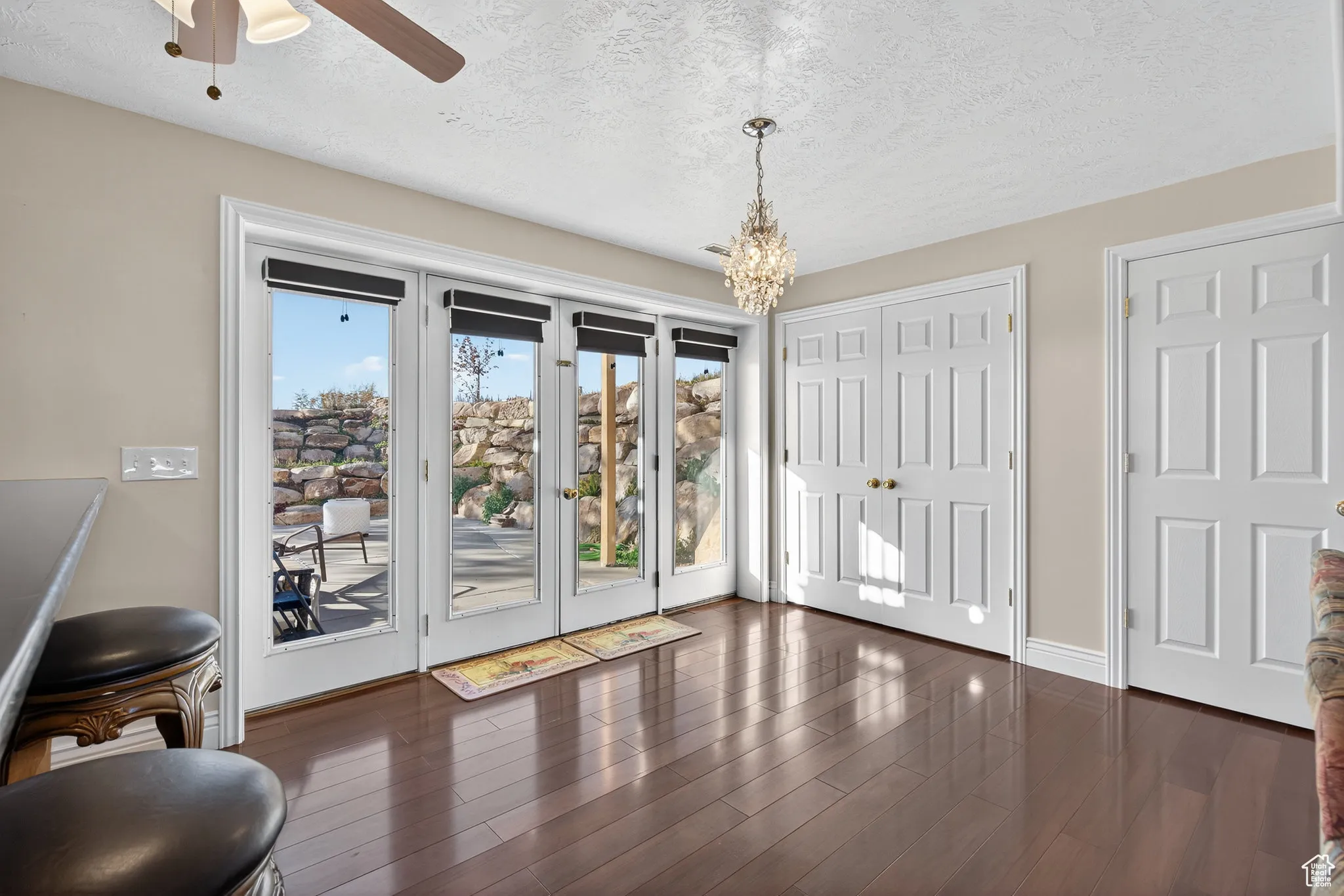 Basement kitchen dinning area, wood-style flooring, ceiling fan, and a chandelier, doors to patio.
