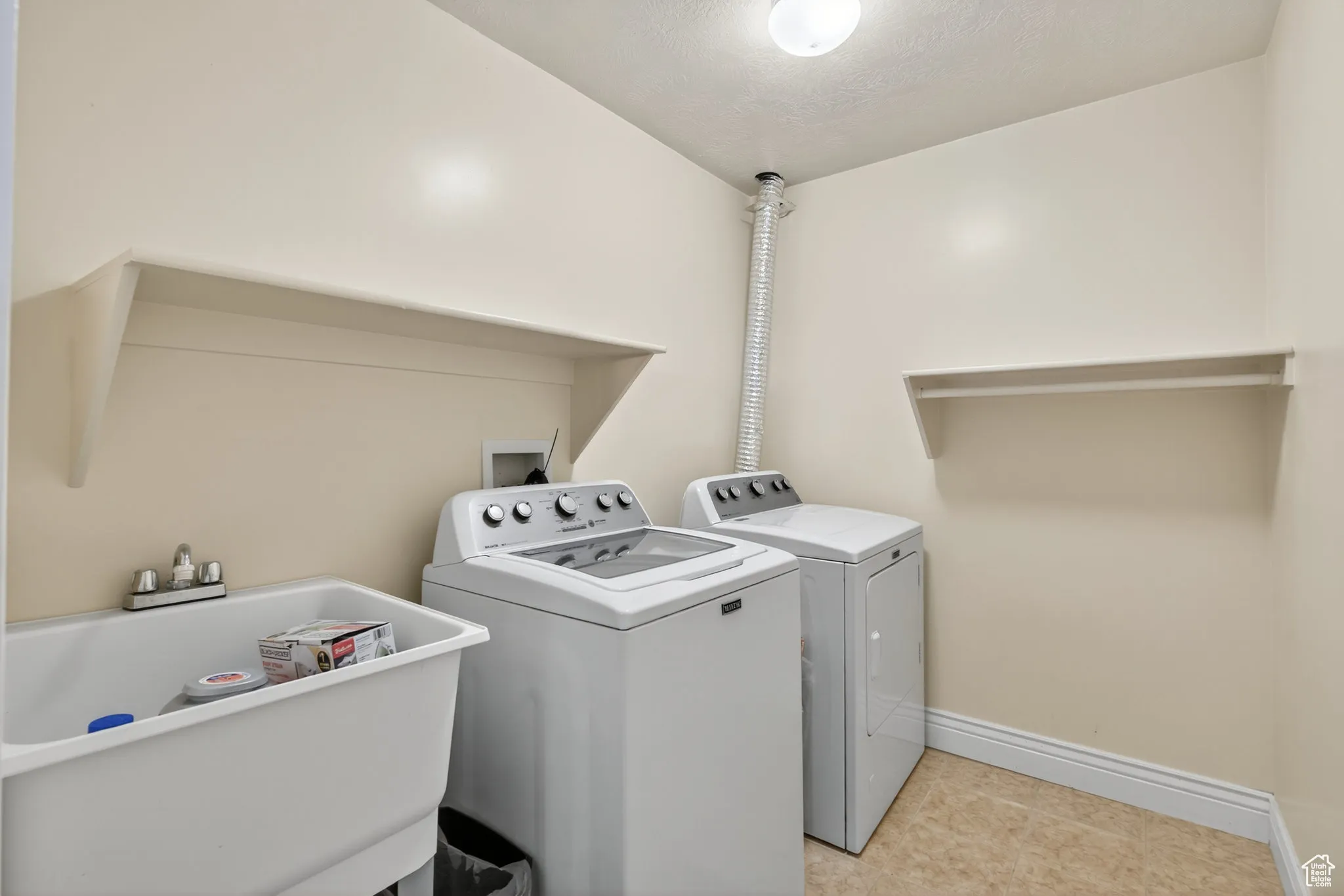 Basement laundry room featuring separate washer and dryer and shelfs.