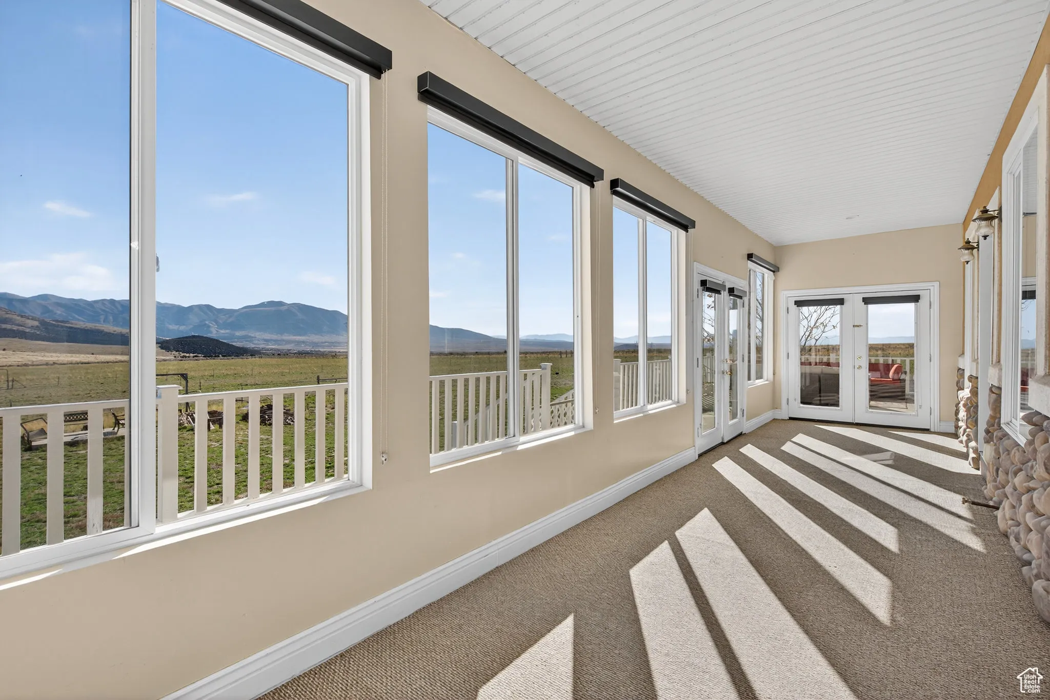 Sunroom with a mountain view, carpet floors, and french doors.